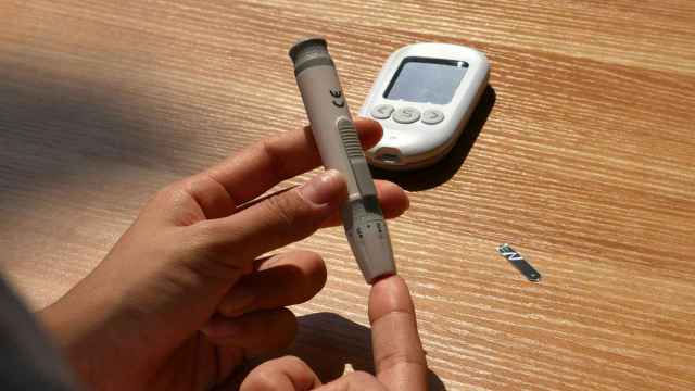 Una persona pinchándose para medir la glucosa.