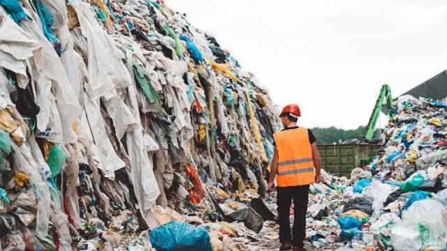 Trabajador rodeado de montañas de residuos textiles. Getty Images