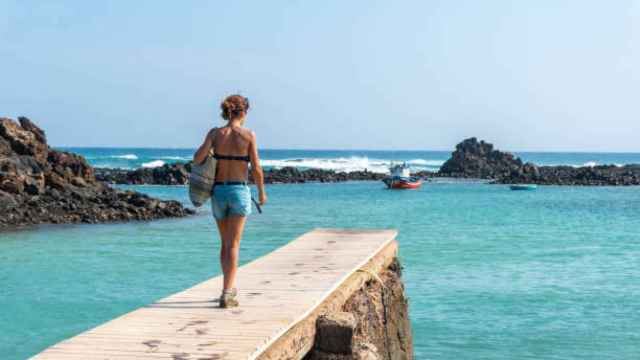 Una mujer camina por una pasarela de una playa de Fuerteventura