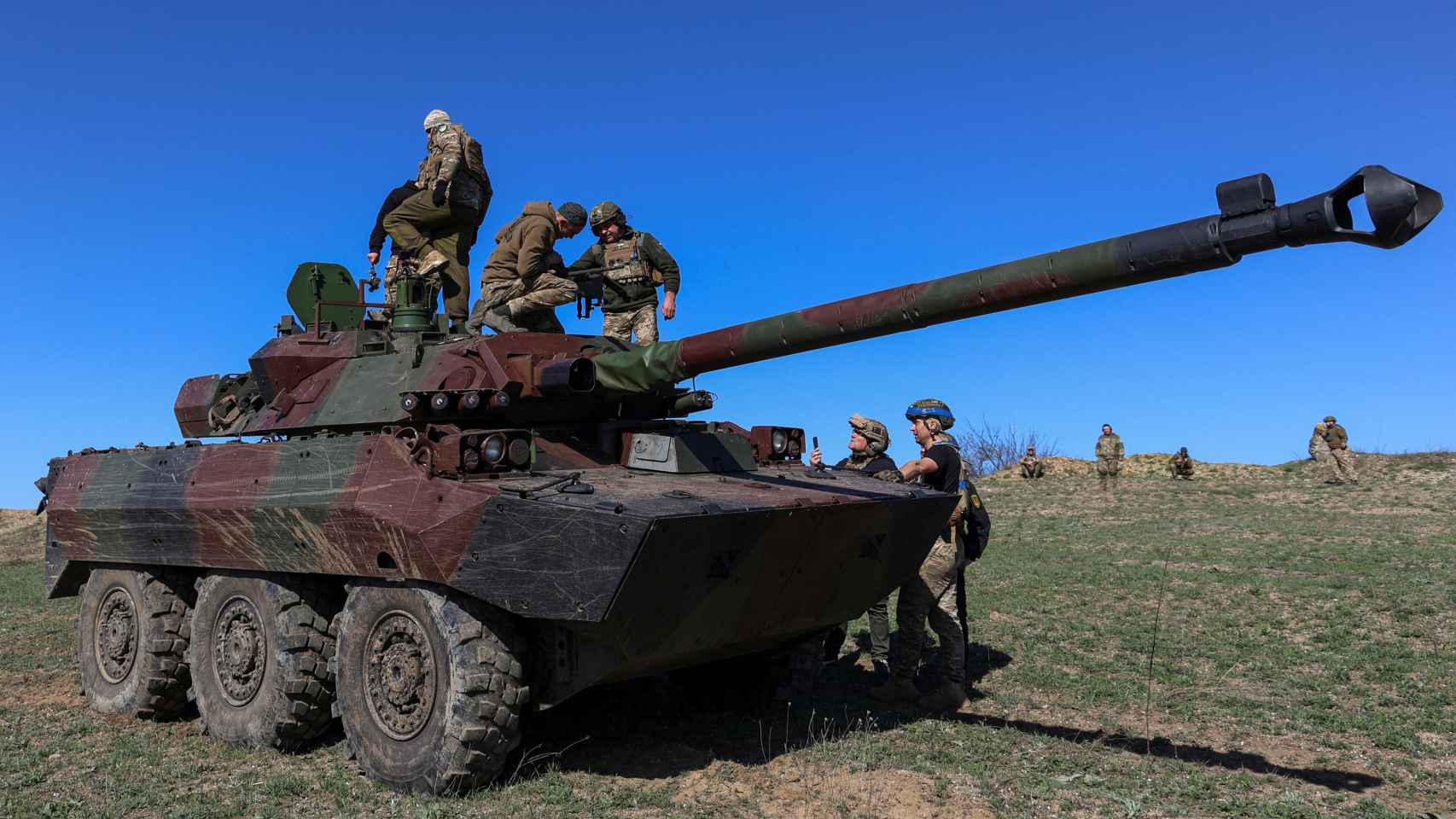 Varios brigadistas ucranianos se suben a un vehículo blindado de combate francés AMX-10 RC.
