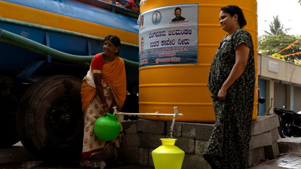 Residentes llenan recipientes con agua de tanques suministrados por la BWSSB.