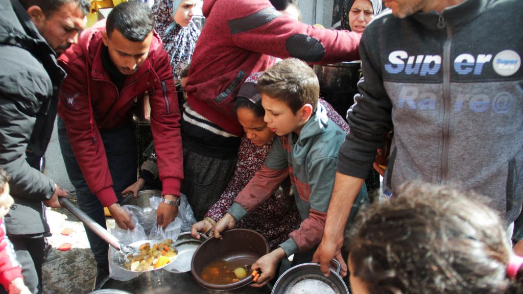 Familias palestinas recibiendo comida en Jabalia, al norte de la Franja de Gaza.