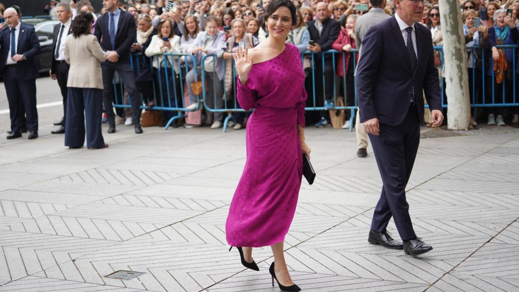 Ayuso ha escogido un vestido largo fucsia con unos stilettos negros a juego con su bolso y un discreto tocado.