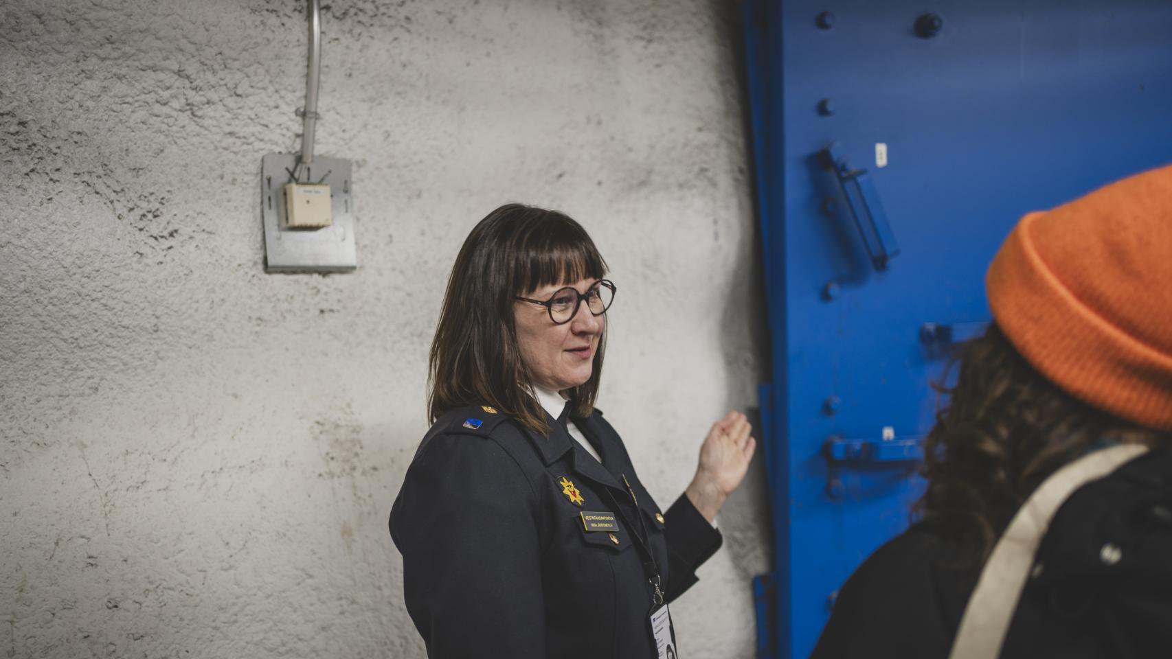 Nina Järvenkylä, Communications Specialist at the Helsinki Rescue Department, shows one of the shelter's armored doors.