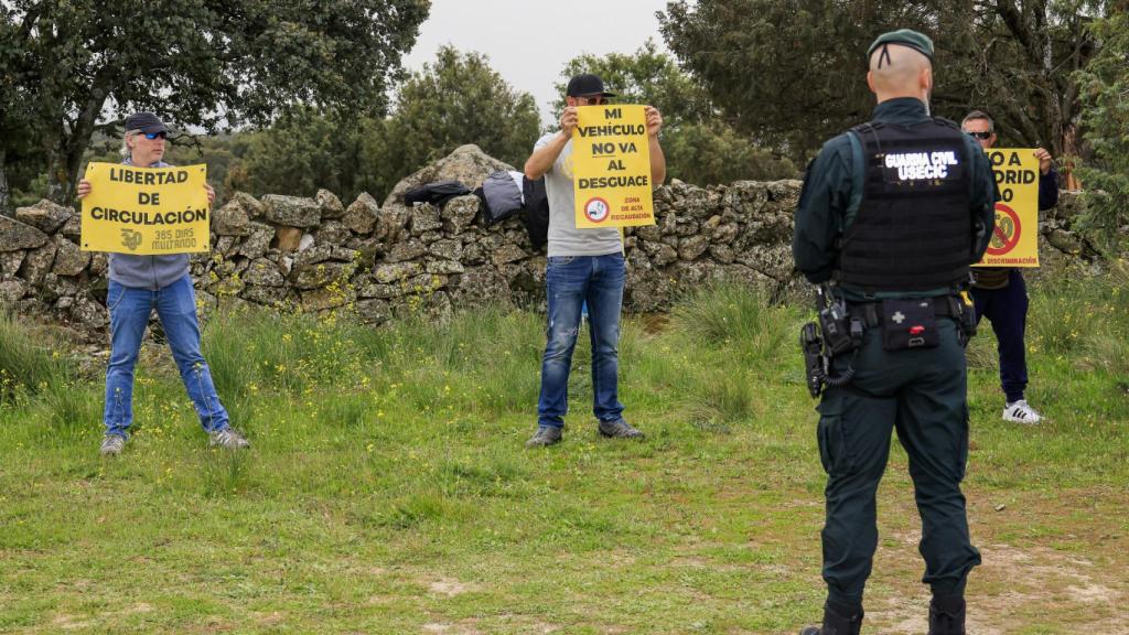 Hombres sosteniendo pancartas en la finca este 6 de abril.