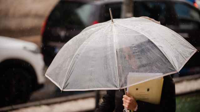 Una mujer sujeta un paraguas.