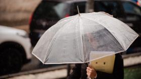 Una mujer sujeta un paraguas.