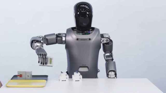 El robot humanoide chino Walker S cogiendo un objeto.