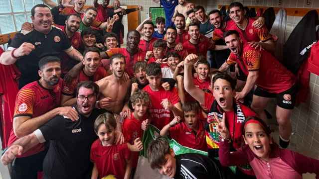 Los jugadores y técnicos del Jove Español celebran la clasificación para la fase de ascenso con sus familiares en el vestuario.