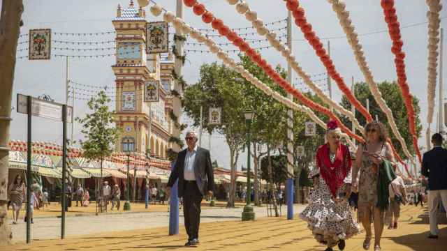 Varias personas pasean por el Real de la Feria en 2023.