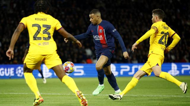 Kylian Mbappé controla ante la presencia de varios jugadores del Barça.