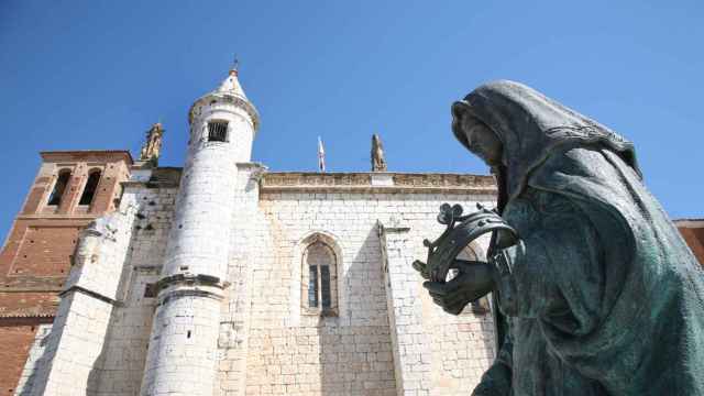Escultura de Juana La Loca en Tordesillas, al fondo la iglesia de San Antolín.