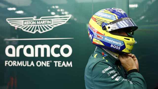 Fernando Alonso se ajusta el casco en el box de Aston Martin