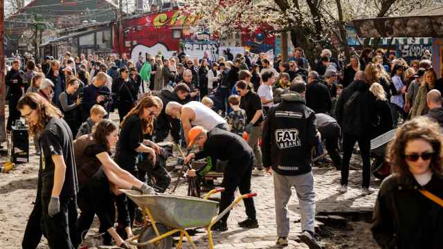Un grupo de personas retirando, piedra a piedra, los adoquines de la calle Pusher en Christiania.