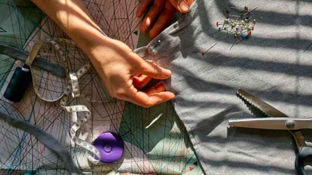 Detalle de una persona trabajando en un taller textil. iStock