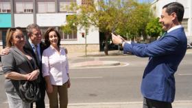 Juanma Moreno haciendo una fotografía a Emiliano García-Page junto a dos mujeres.