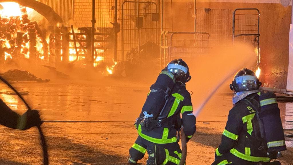 Dos bomberos apagando un incendio en Madrid.