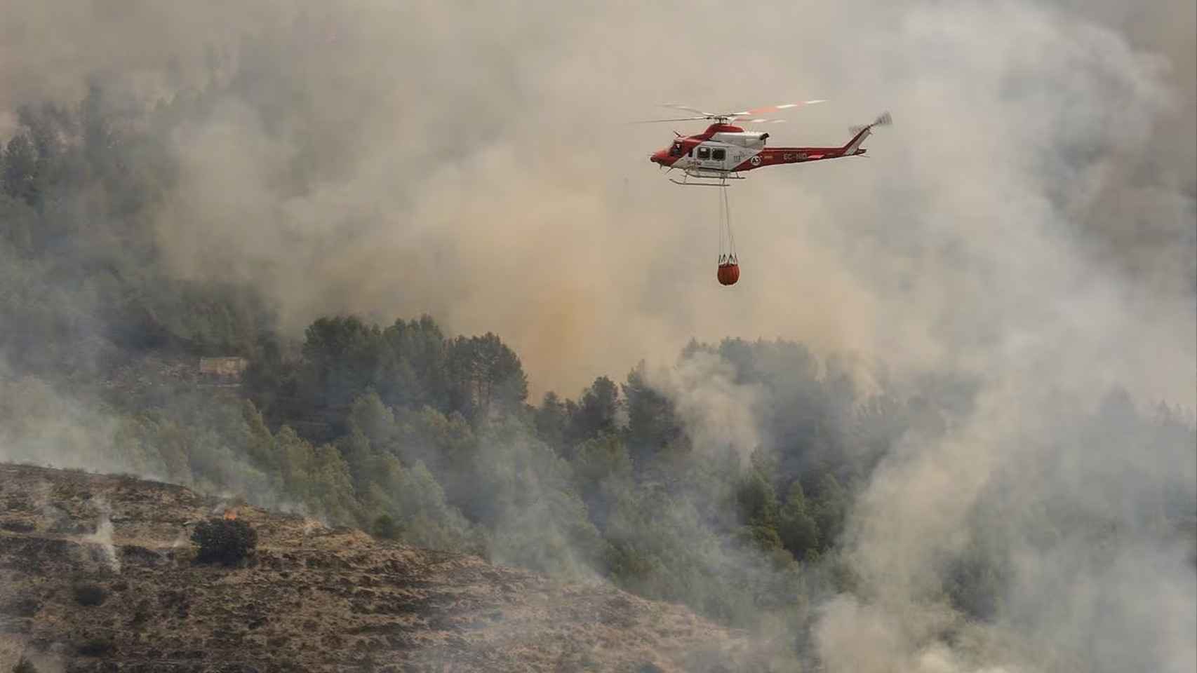 Un helicóptero de los Servicios de Emergencia trabaja en la extinción del incendio forestal de Tárbena (Alicante).