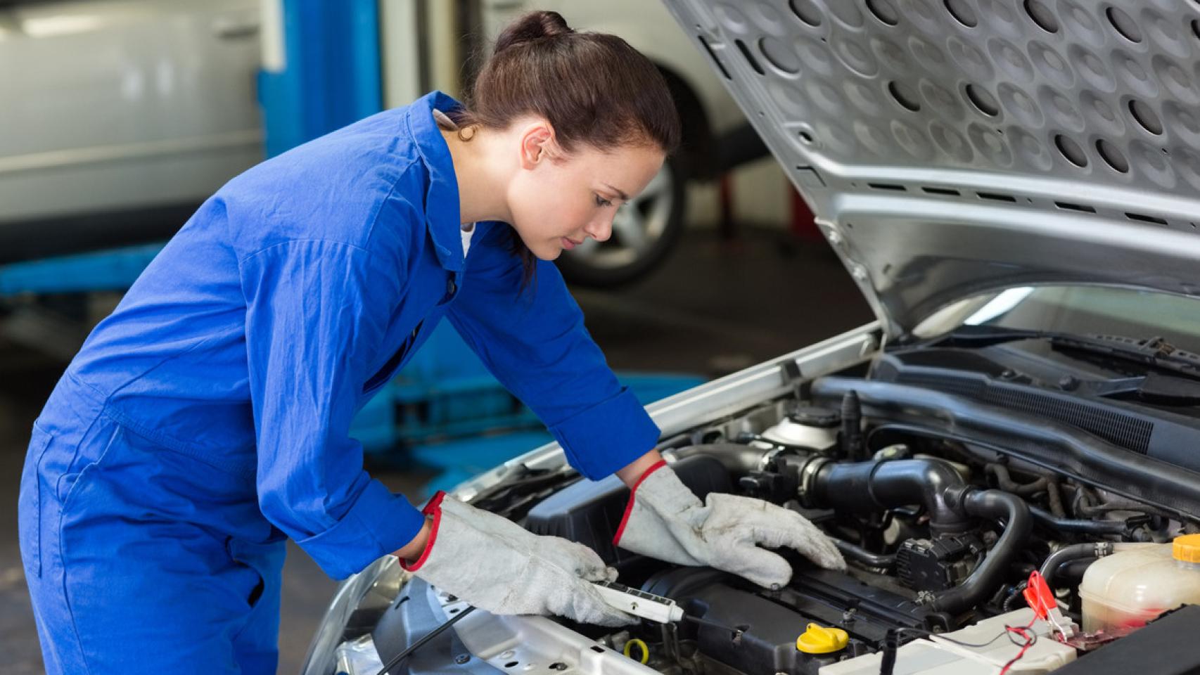 Imagen de una mujer reparando un coche.