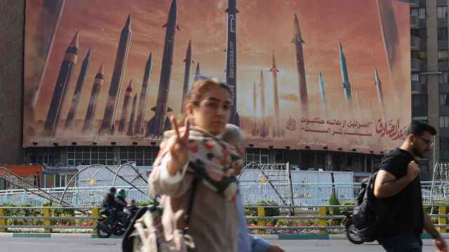 Una mujer sin velo hace una señal de la victoria delante de una valla publicitaria de misiles iraníes, este lunes en Teherán.