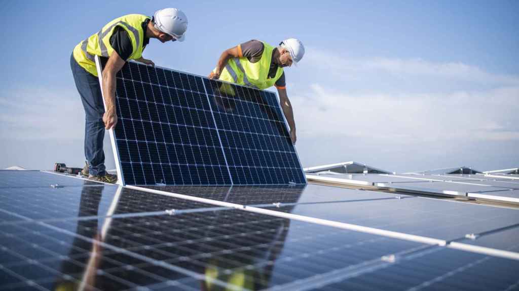 Dos ingenieros instalando un panel solar.