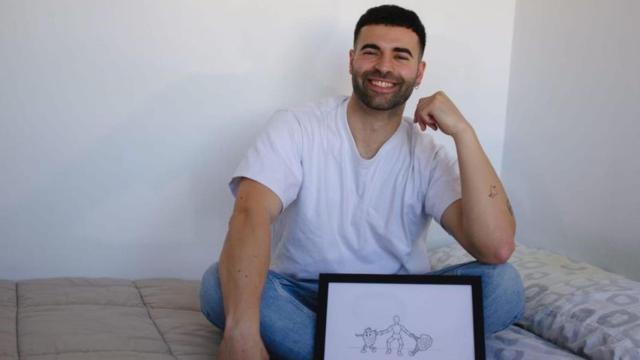 El artista coruñés Bruno Díaz Boudín posa con uno de sus dibujos