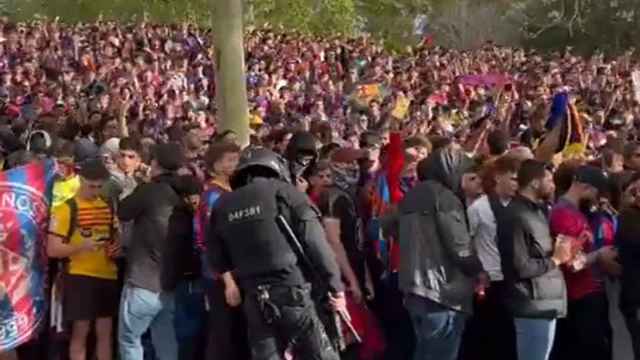 Varios aficionados del Barça esperan la llegada de los autobuses en la previa del partido contra el PSG.