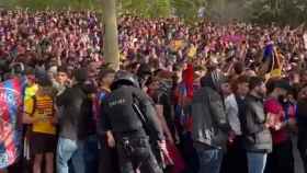Varios aficionados del Barça esperan la llegada de los autobuses en la previa del partido contra el PSG.