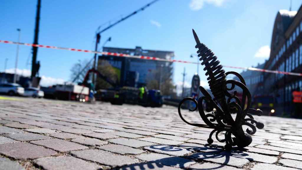 La punta de la aguja de la torre de la Bolsa de Copenhague, caída en el suelo tras el incendio que ha asolado el edificio.