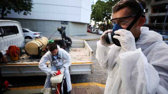 Unos operarios se preparan para fumigar zonas con mosquitos transmisores en Argentina.