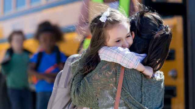 Imagen de archivo de una menor abrazando a su madre en la escuela.