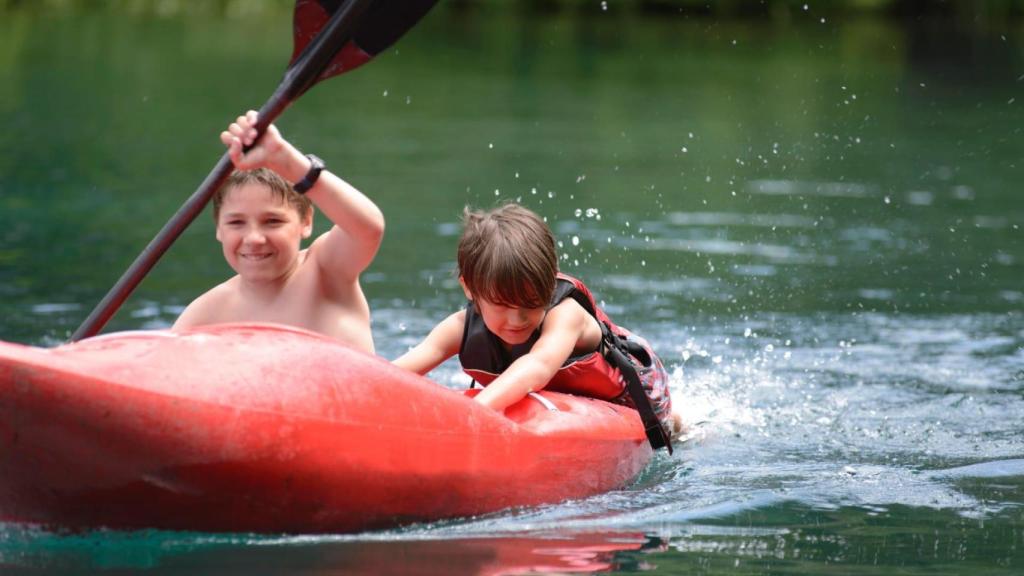 Un niño practica kayak