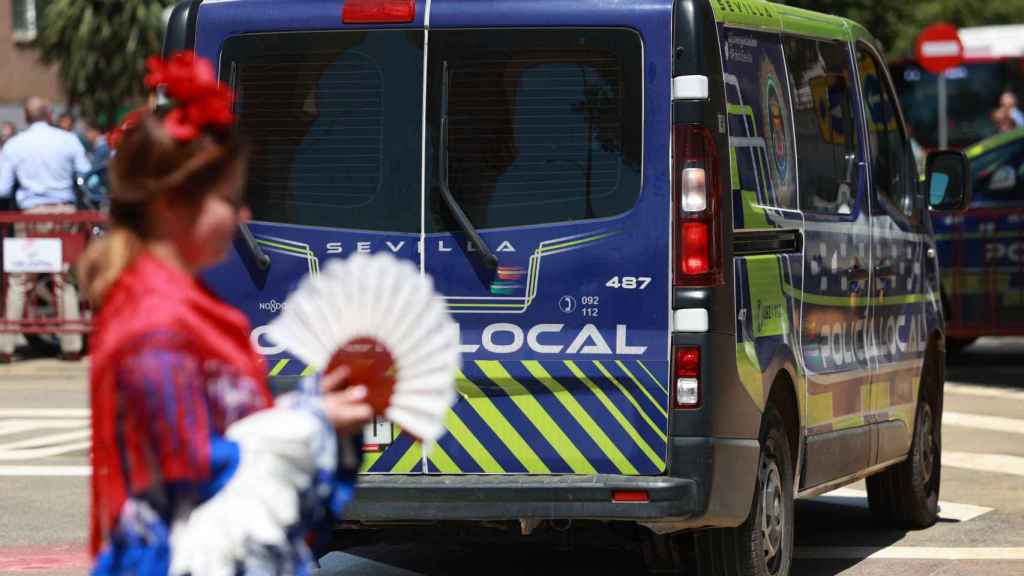 Una flamenca camina junto a un vehículo de la Policía Local.
