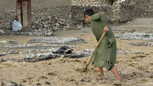 Un niño intenta arreglar los estragos de las inundaciones en Afganistán