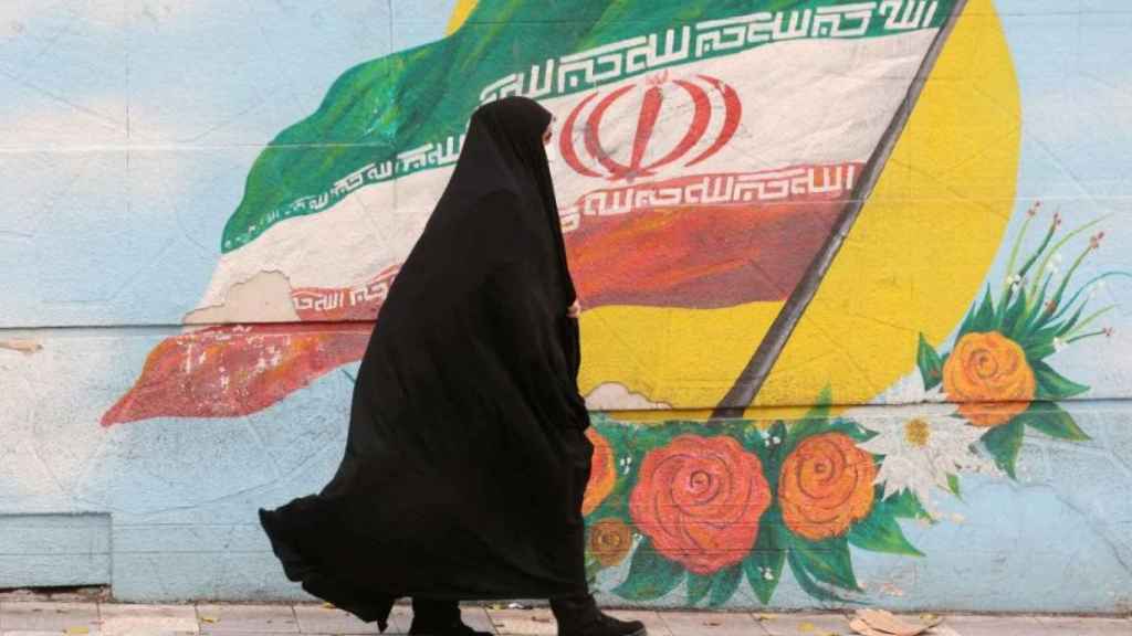 Una mujer iraní completamente cubierta con el velo islámico en una calle de Teherán.
