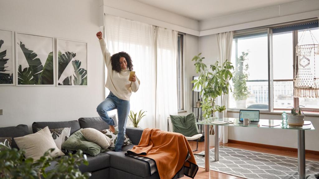 Mujer feliz sobre el sofá.