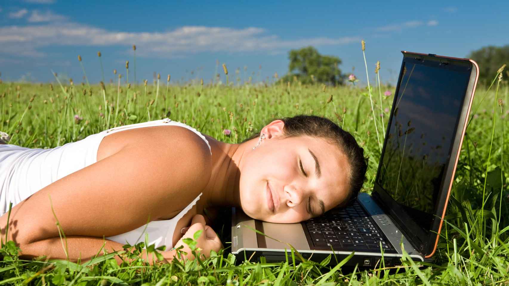 Una joven descansa sobre el teclado de su portátil