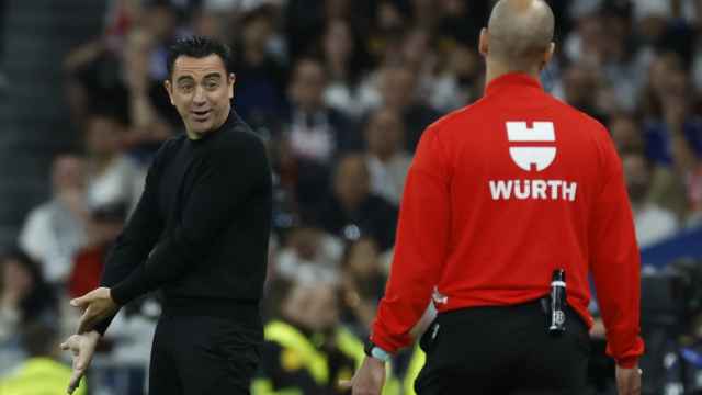 Xavi le pide explicaciones al cuarto árbitro durante el partido.