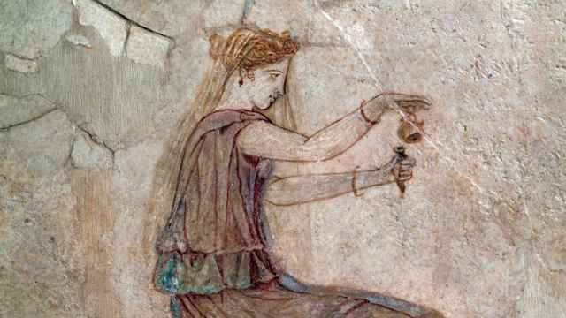 Pintura del siglo I de una mujer vertiendo perfume en un frasco.