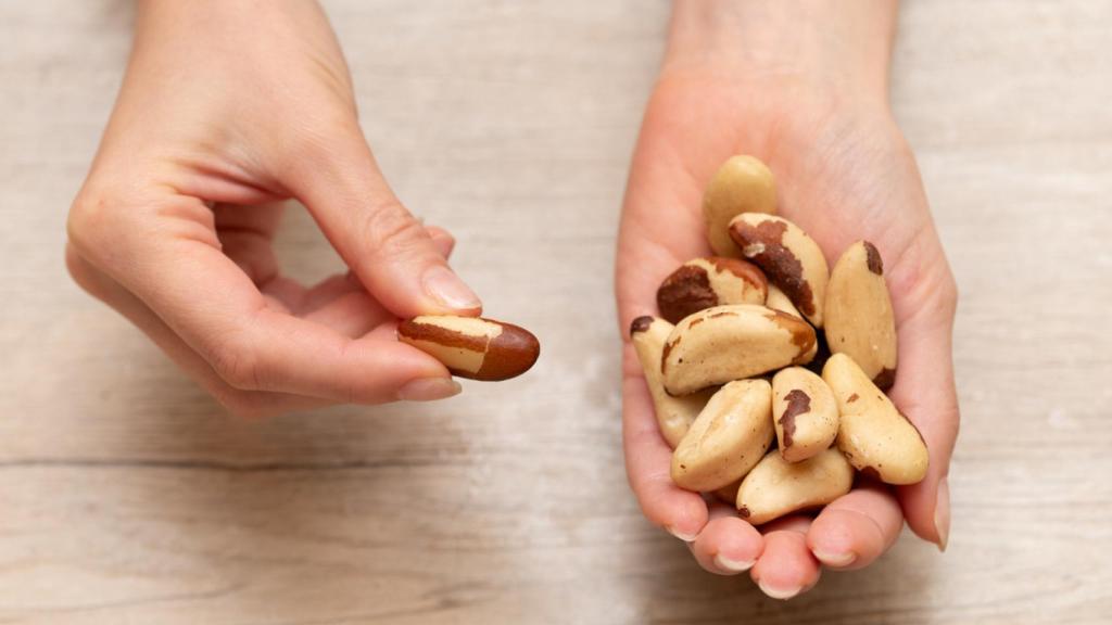 Manos sosteniendo nueces de Brasil.