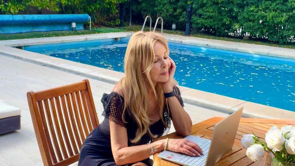 Ana Obregón escribiendo en la zona de la piscina de su casa de La Moraleja.