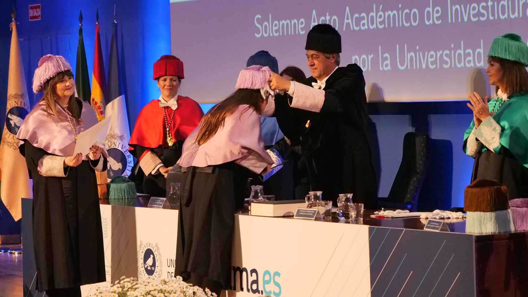 El rector colocándole el birrete a una de las nuevas doctoras de la Universidad de Málaga.