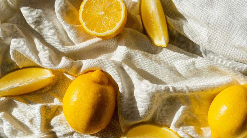 Limones enteros y partidos sobre una sábana.