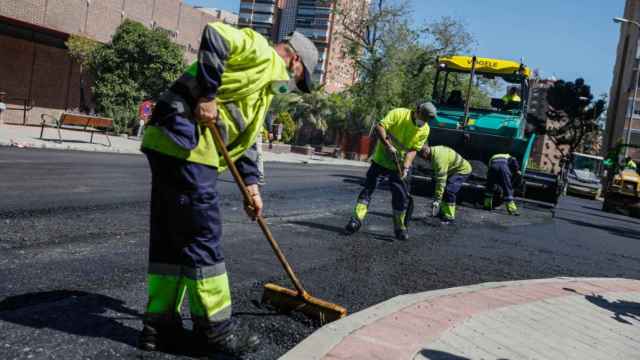Operarios durante los trabajos de reasfaltado en una calle de Madrid.