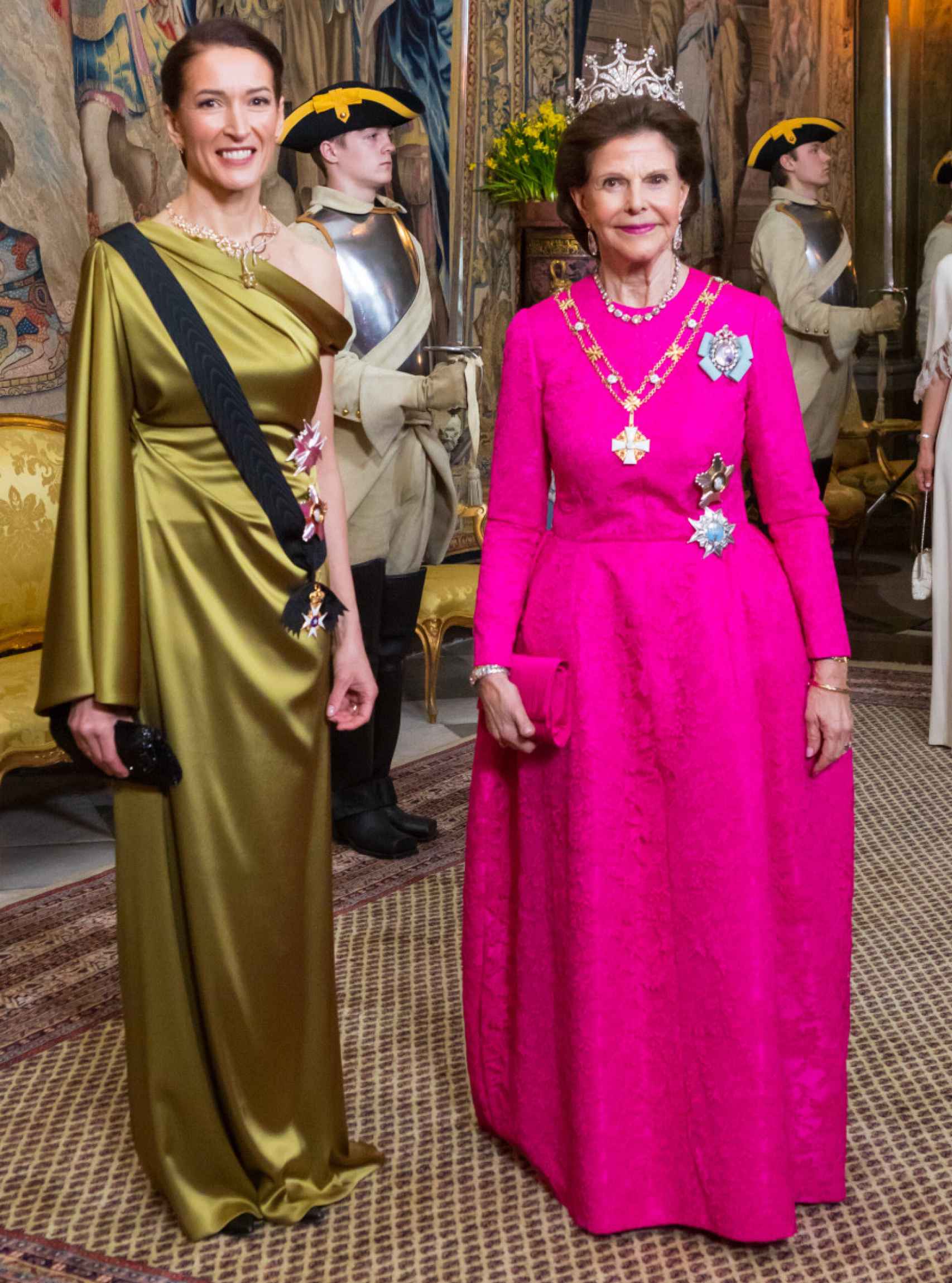 La Reina, con la Primera Dama de Finlandia, a su entrada al salón de palacio.