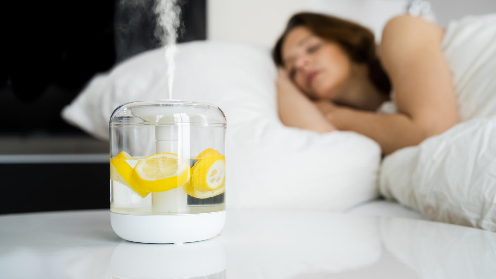 Mujer durmiendo junto a un aromatizador con limones.