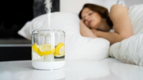 Mujer durmiendo junto a un aromatizador con limones.