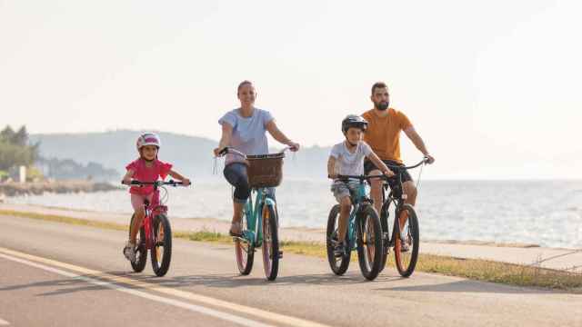Dos niños y dos adultos montando en bicicleta