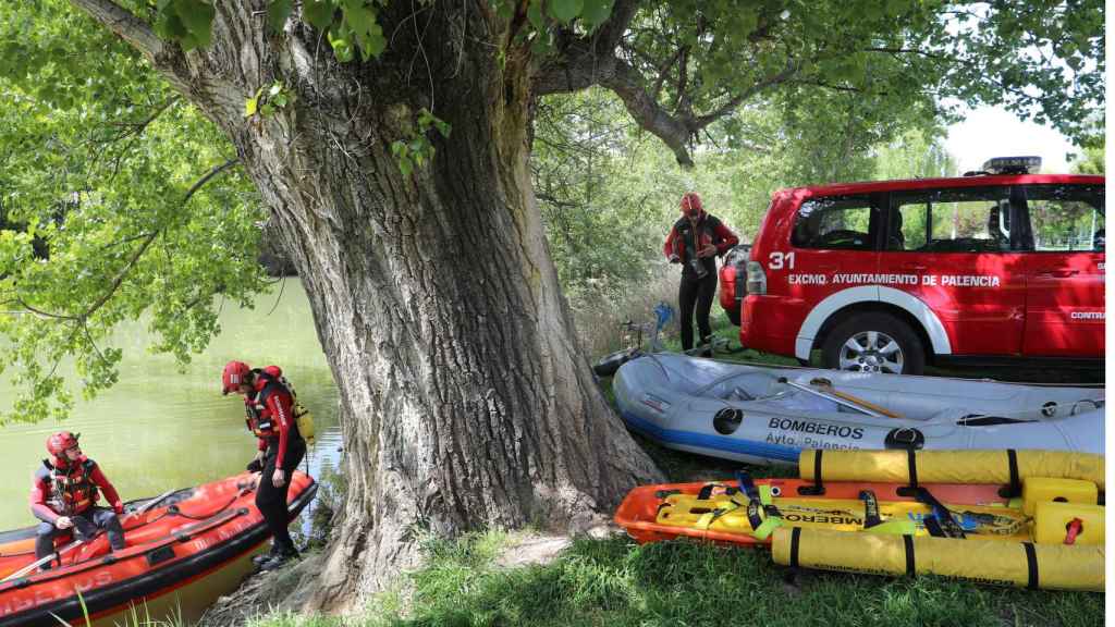 os bomberos profesionales del parque de Palencia participan en el dispositivo de búsqueda de un hombre de 93 años con movilidad reducida que lleva un día desaparecido, en la imagen inspeccionan la orilla del río Carrión a su paso por la capital