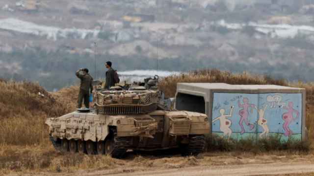 Soldados israelíes observan Gaza subidos sobre un tanque.